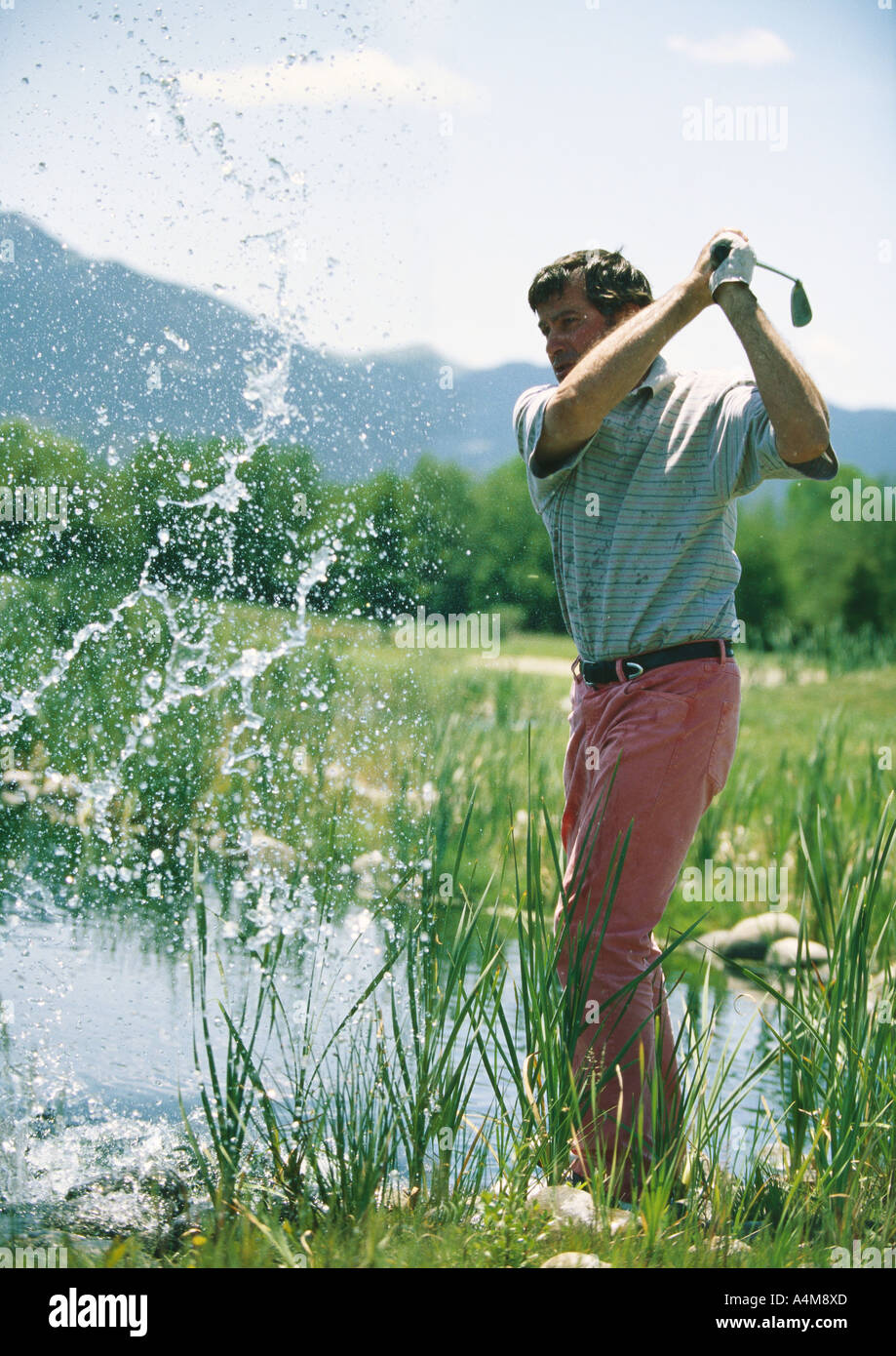 Golfspieler schwingen im Wasser Stockfoto