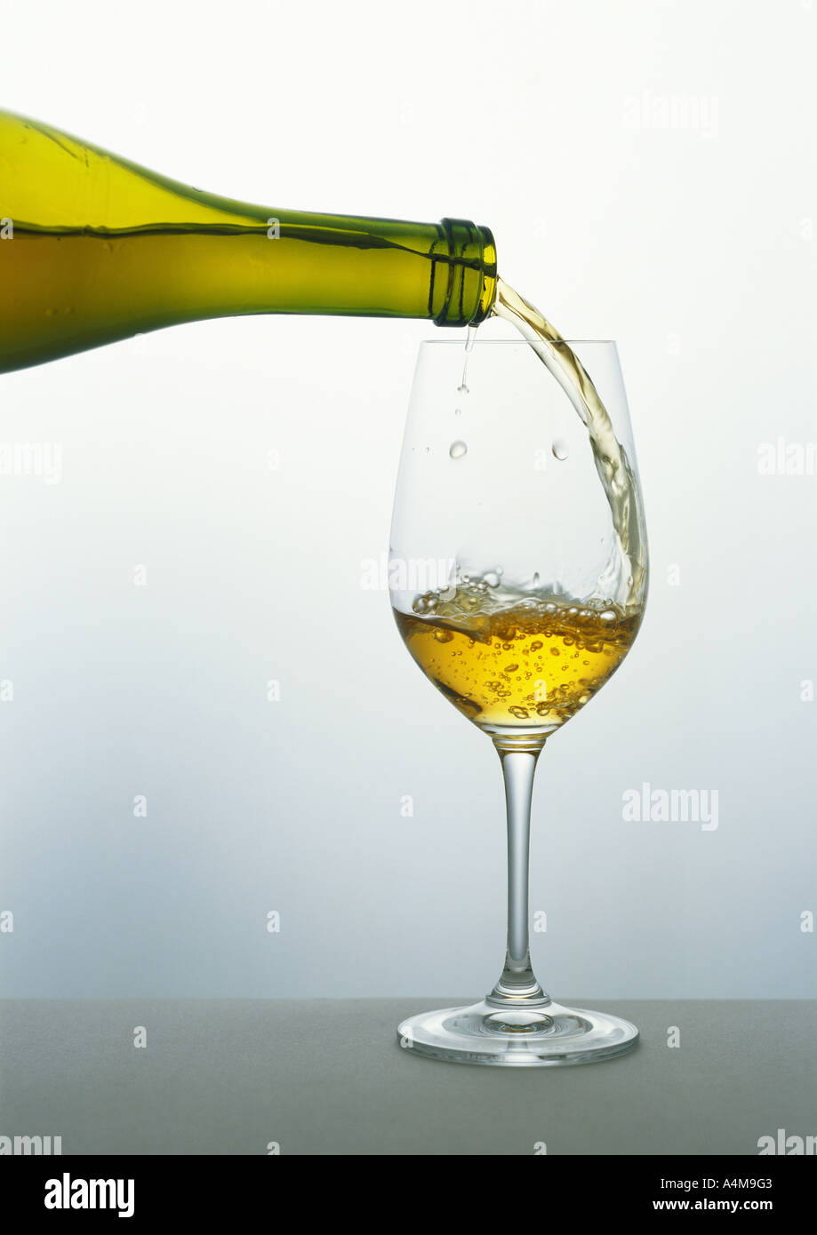 Gießen ein Glas Weißwein Stockfoto