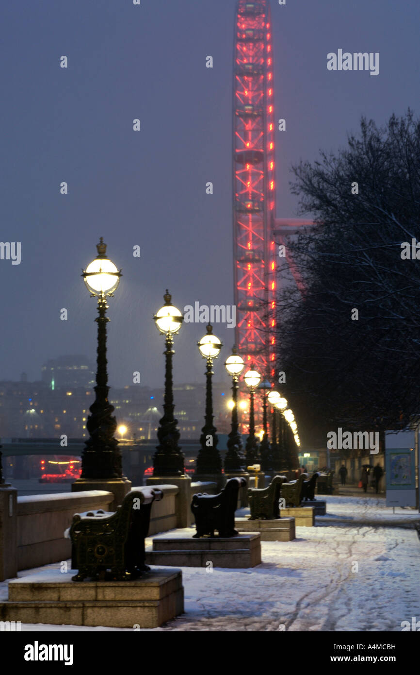 Das London Eye und die Themse Damm in London nach einem Schneefall. Stockfoto