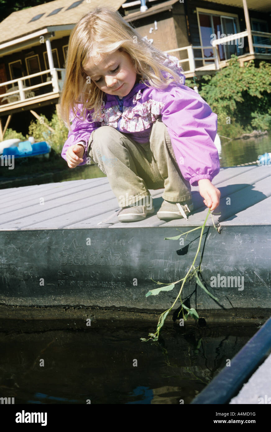 MÄDCHEN (CA. 3-5 JAHRE.) EINTAUCHEN IN WASSER VERZWEIGEN Stockfoto