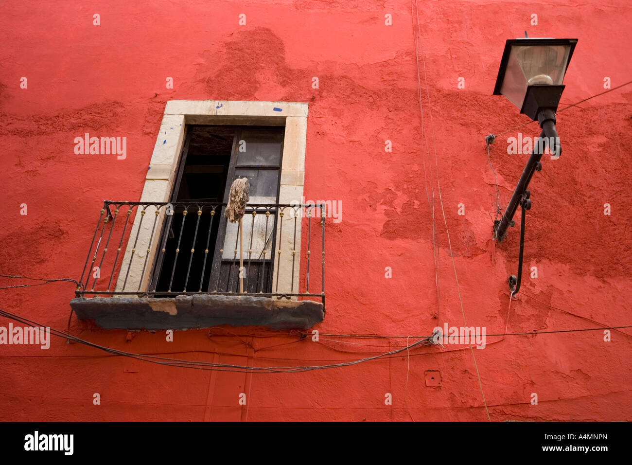 Öffnen Sie Fenster stehend auf einer roten Wand (Guanajuato - Mexiko). Fenêtre Ouverte Sur Mur Rouge (Guanajuato - Mexique). Stockfoto