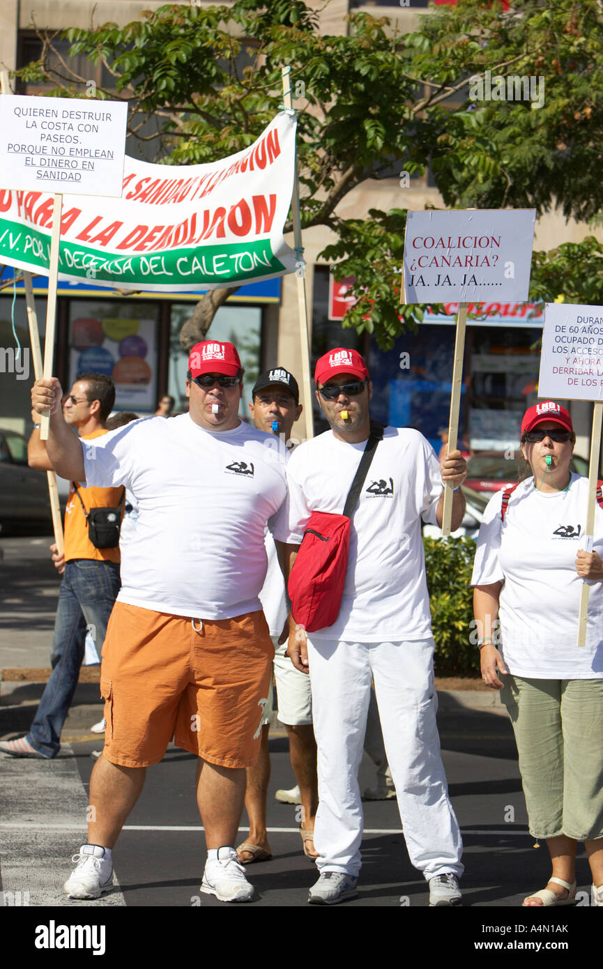 vertikale drei spanische Demonstranten zeigen, halten Plakate mit roten Hüten weht Pfeifen in Santa Cruz Stockfoto