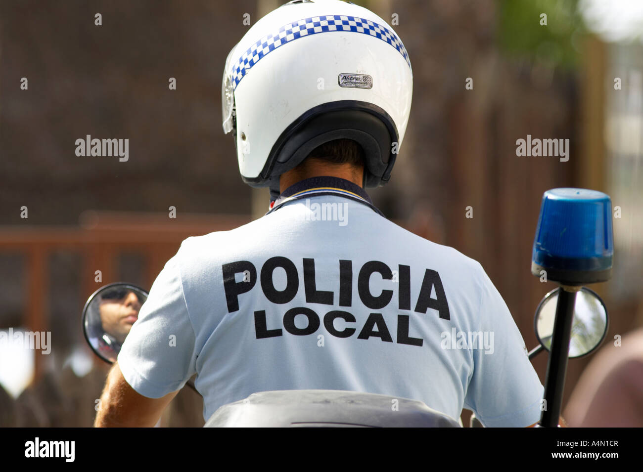spanische Policia lokaler Polizist schaut in seine Rückansicht Seitenspiegel auf seinem Fahrrad vor der Fahrt Stockfoto