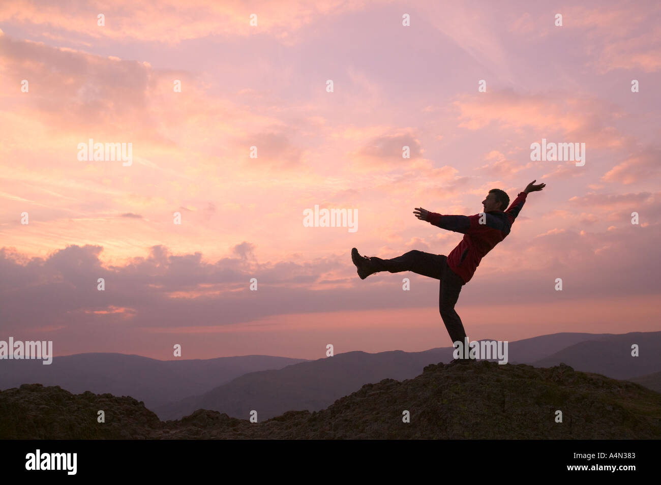 Man übt Gleichgewicht bewegt sich bei Sonnenuntergang Stockfoto