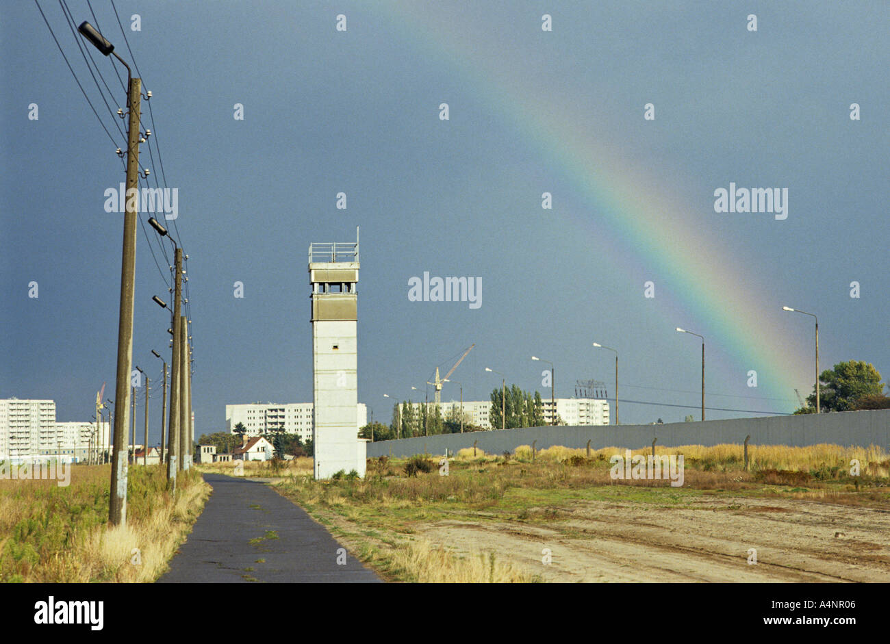 Regenbogen als Zeichen des Friedens und der Wiedervereinigung 1990 über die Berliner Mauer mit Wachturm Stockfoto