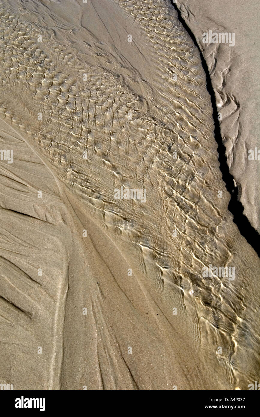 Kleines Rinnsal Wasser fließt zurück ins Meer bei Ebbe Stockfoto