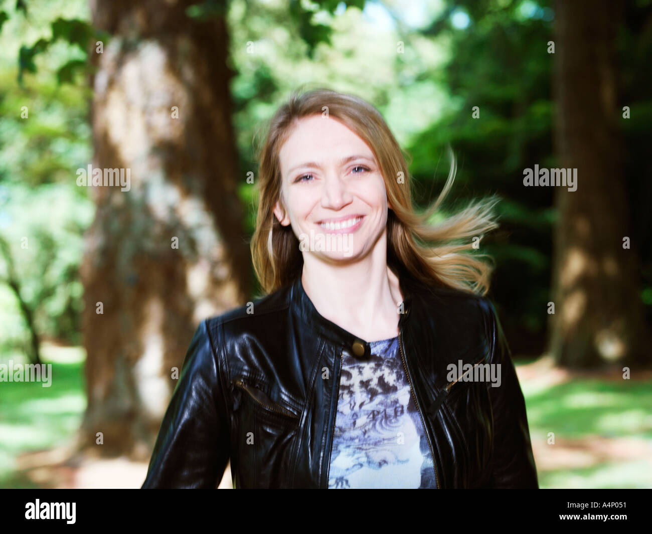 Porträt von 30 Frau lächelnd in Holz Haar im wind Stockfoto