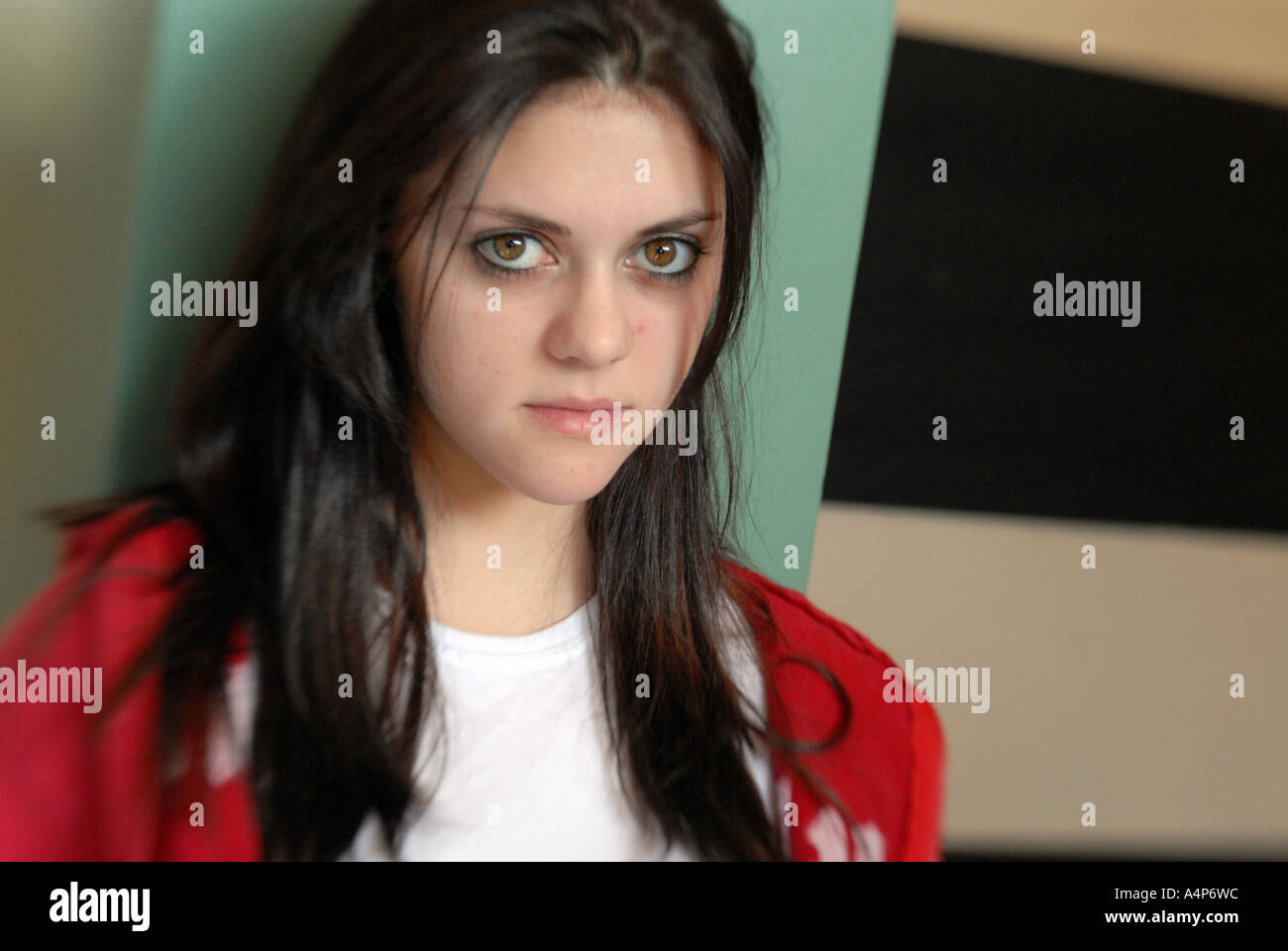 Junge Teen heranwachsenden Mädchen zur Schule tragen rote Jacke mit großen braunen Mandelaugen und lange dunkle Haare Stockfoto