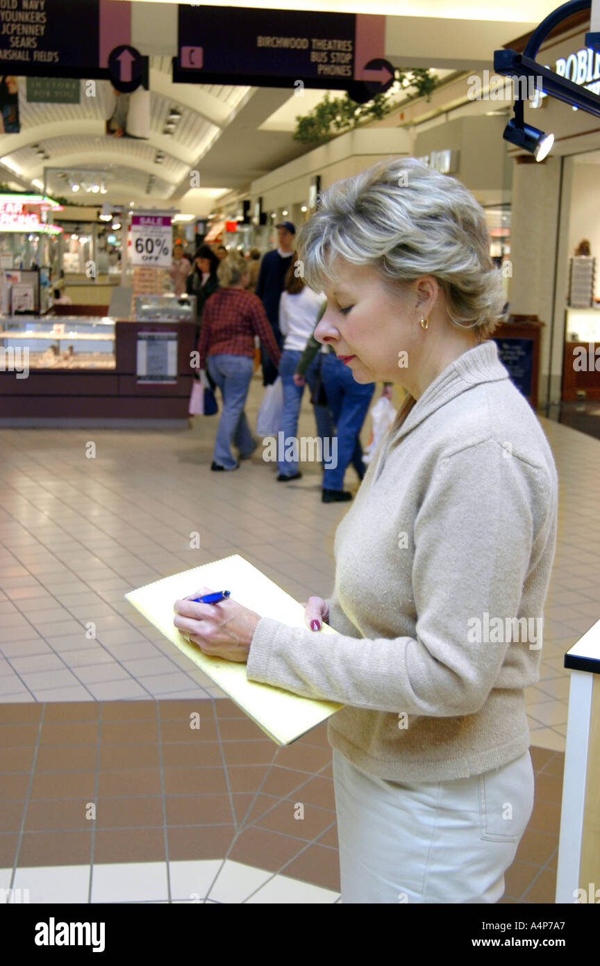 Frau findet eine Befragung von Kunden in einem großen Einkaufszentrum Stockfoto