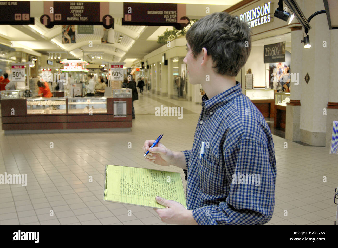 Mann nimmt eine Befragung von Kunden in einem großen Einkaufszentrum Stockfoto