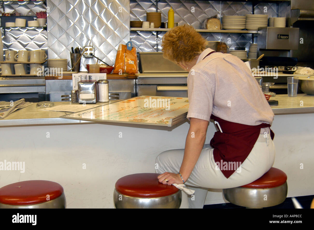 Kellnerin bereitet Menü Specials in einem kleinen Restaurant an der Wand hängen Stockfoto