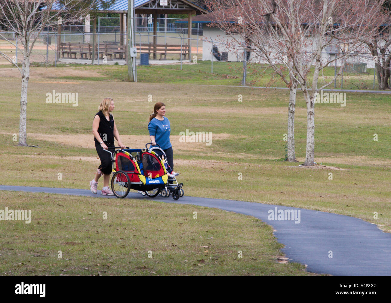 Zwei Frauen zu Fuß und schob Babys im Kinderwagen durch Jervey Gannt Park in Ocala, Florida USA Stockfoto