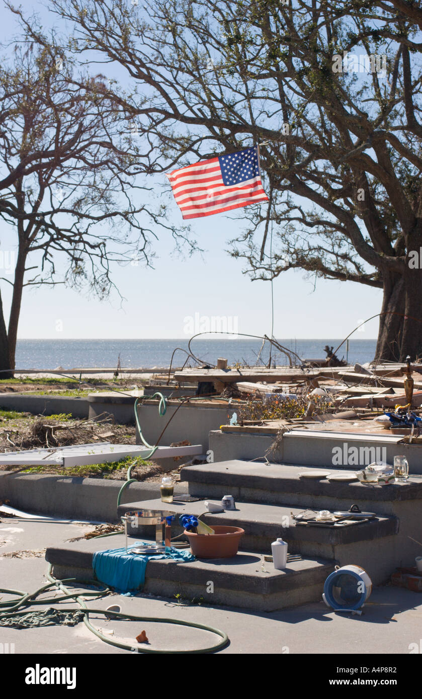 Die amerikanische Flagge schwingt über dem Grundmauern des Strandhauses, und nur wenige verbleibende Besitztümer sind noch auf Veranden gestapelt, sechs Monate nachdem Hurrikan Katrina die Golfküste von Mississippi zerstört hatte Stockfoto