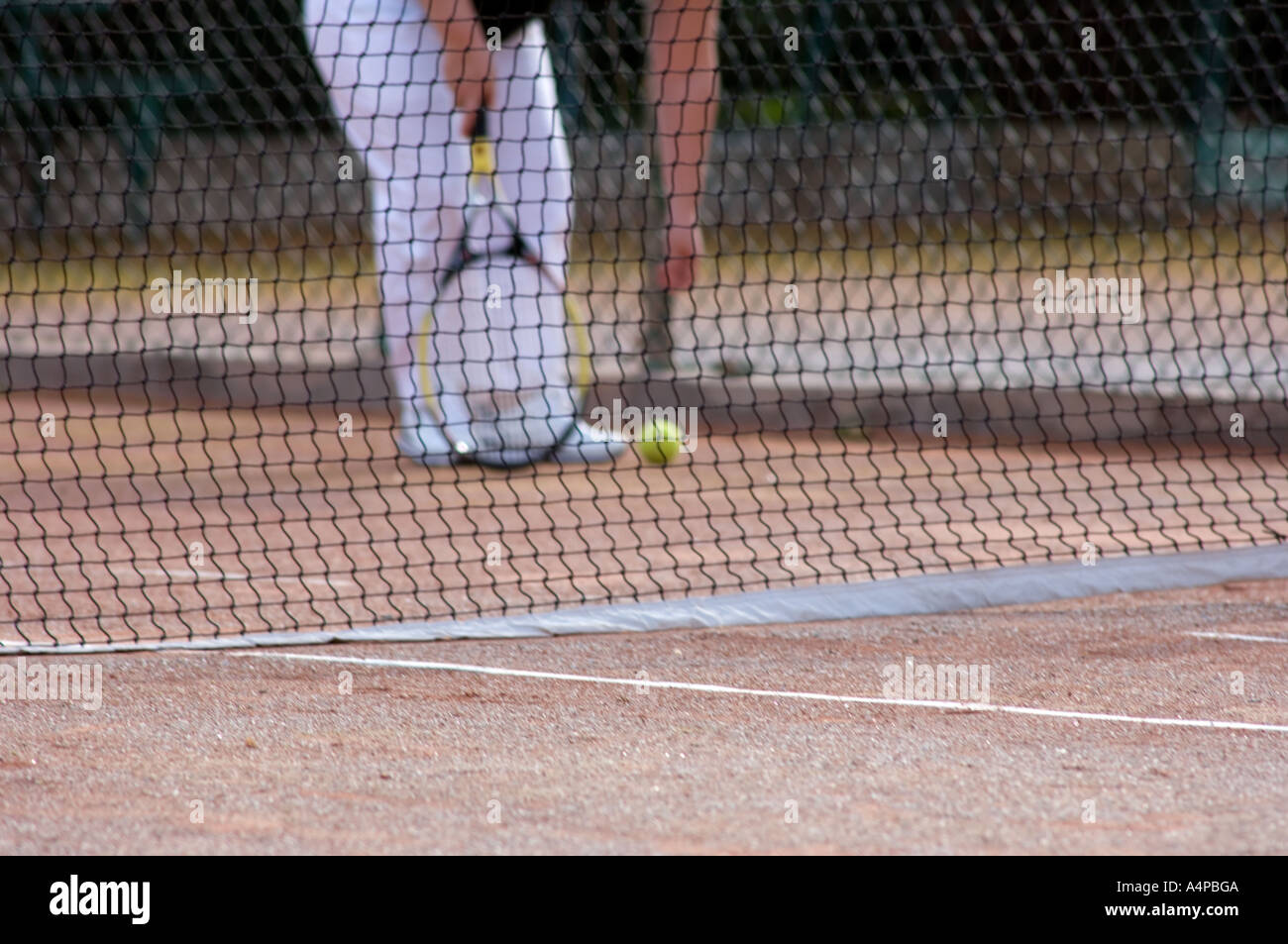 Erwachsene spielen Tennis und das Netz im Fokus Stockfoto