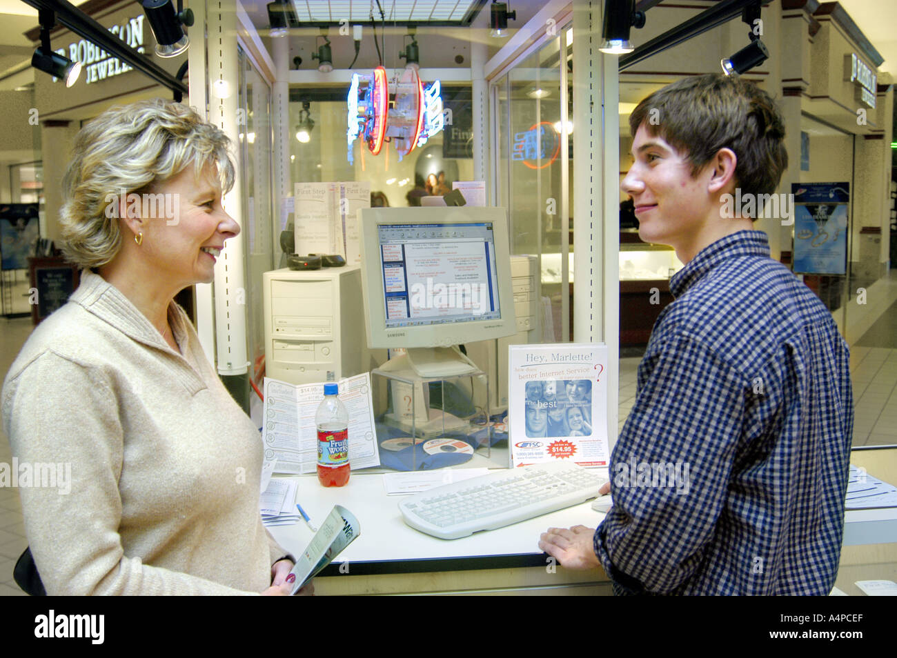 Männchen mit Computer nimmt Umfrage von Käufern in einem großen Einkaufszentrum 2 Stockfoto