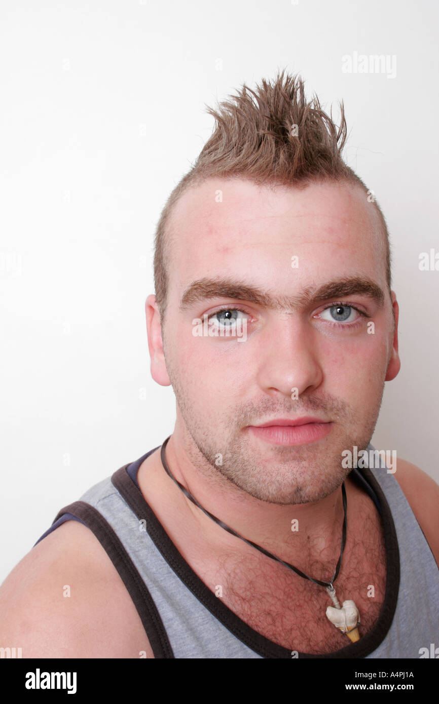 Mohikaner Haarschnitt junger Mann im Alter zwischen 20 und 25 Schuss im Studio auf weißem Hintergrund Stockfoto