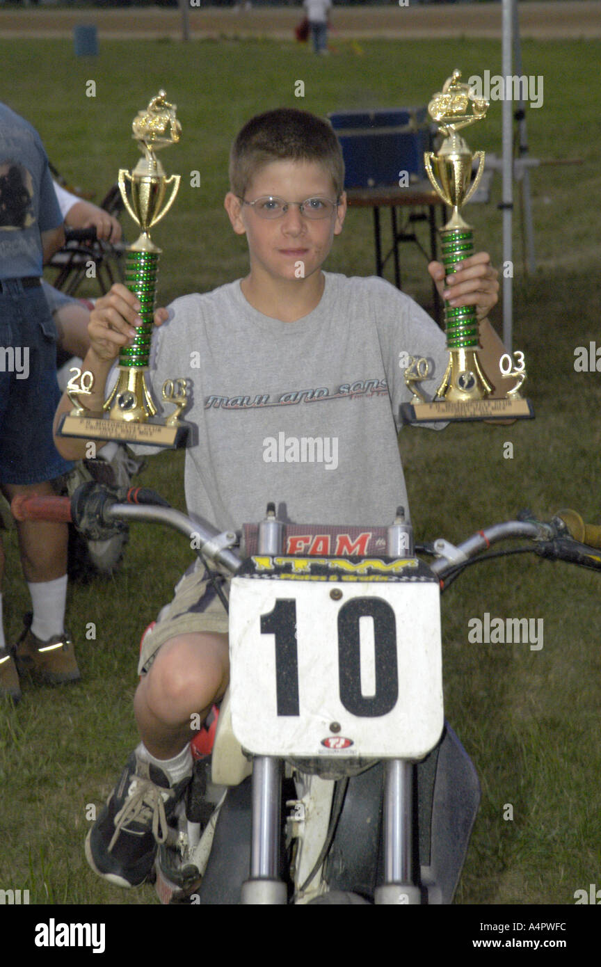 Jr High Boy auf 10 Platte Motorrad hält sich zwei Trophäen nach Dirt-Track Motorrad Rennen Croswell Michigan USA Stockfoto