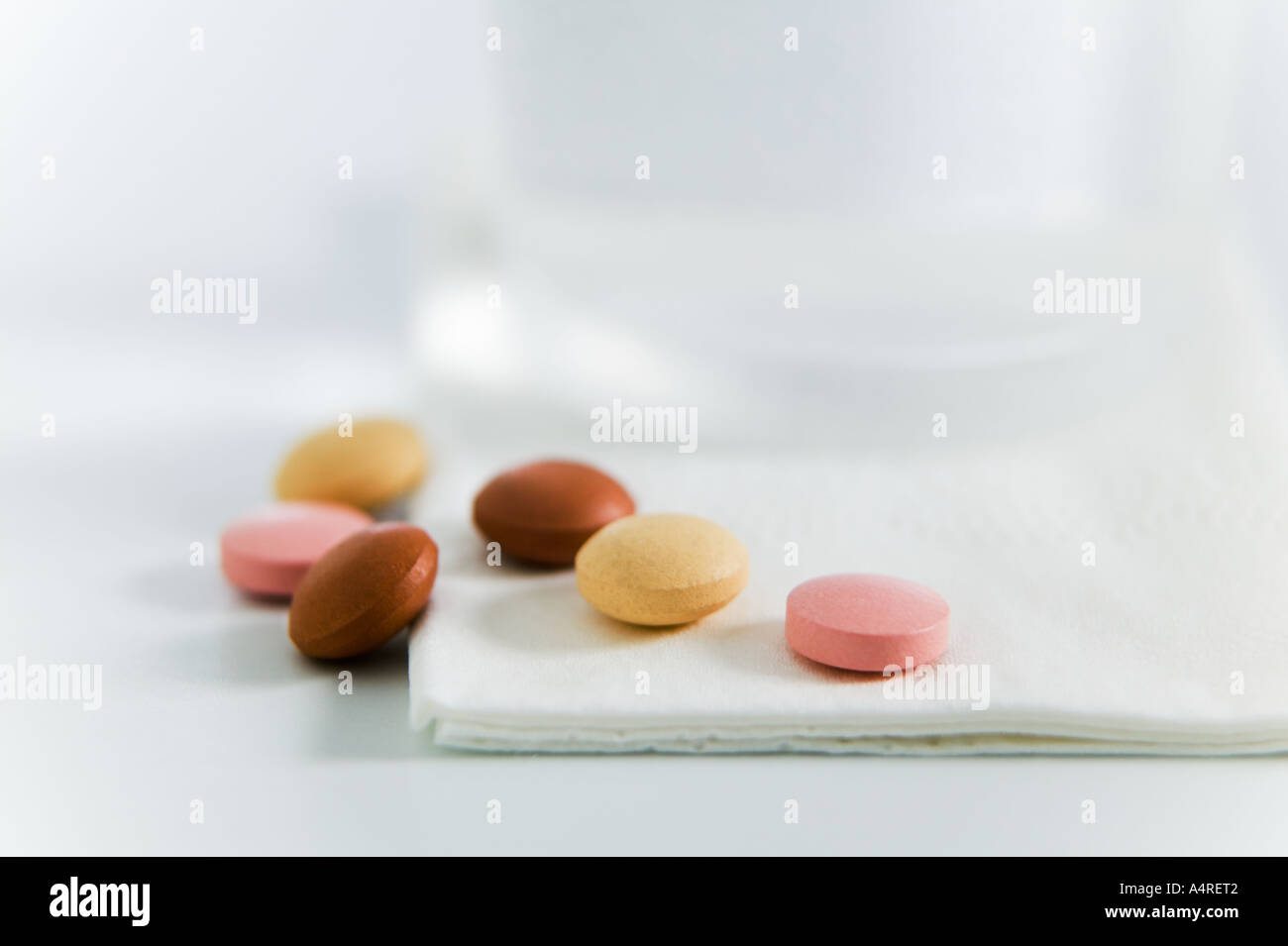Auswahl von Pillen vor Glas Wasser Stockfoto