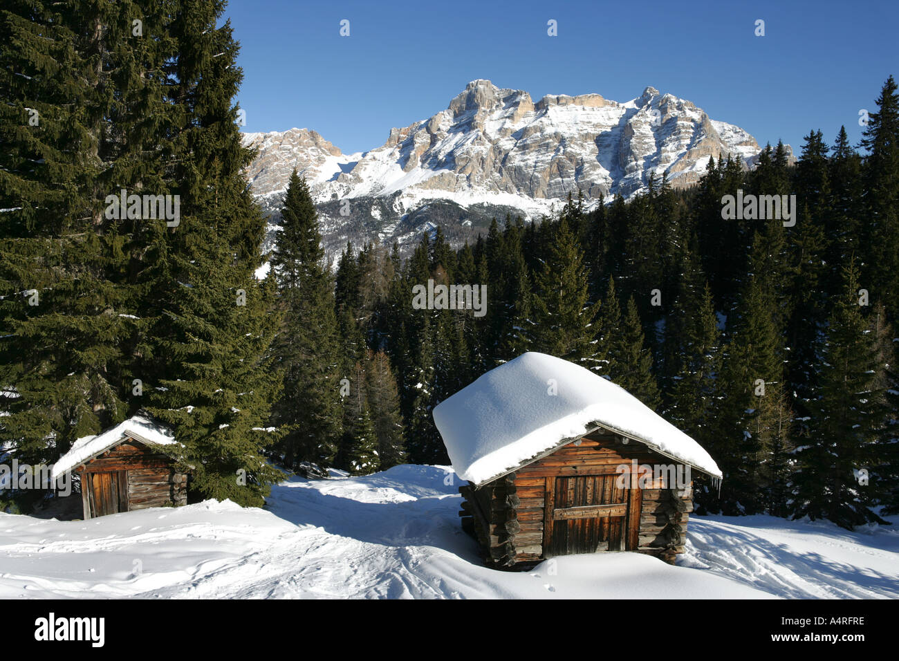 Holzhütten im Wald und die Berge der Dolomiten im Winter. Schnee, Italien Stockfoto