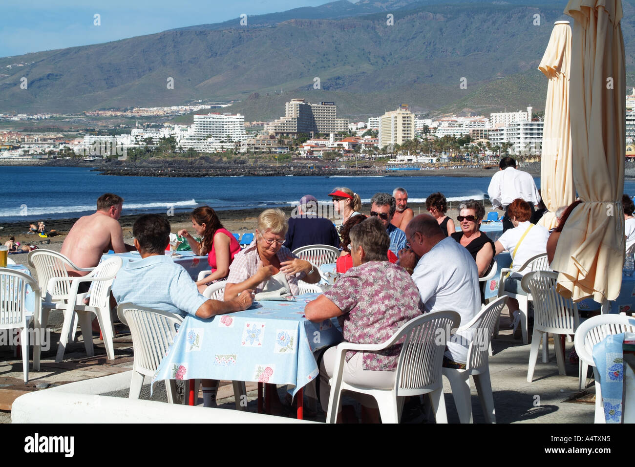 Touristen Essen alfresco entlang der Promenade am Playa de Las Americas Teneriffa Kanarische Inseln Südspanien Stockfoto