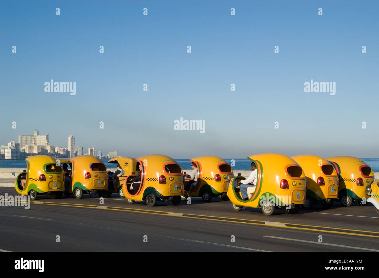 Ein Konvoi von Coco taxis fahren entlang El Malecon in Havanna Kuba Stockfoto