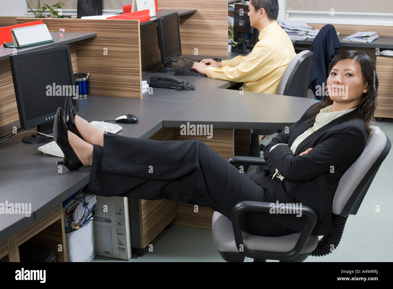 Geschäftsfrau entspannend mit ihren Füßen auf ihrem Schreibtisch Stockfoto