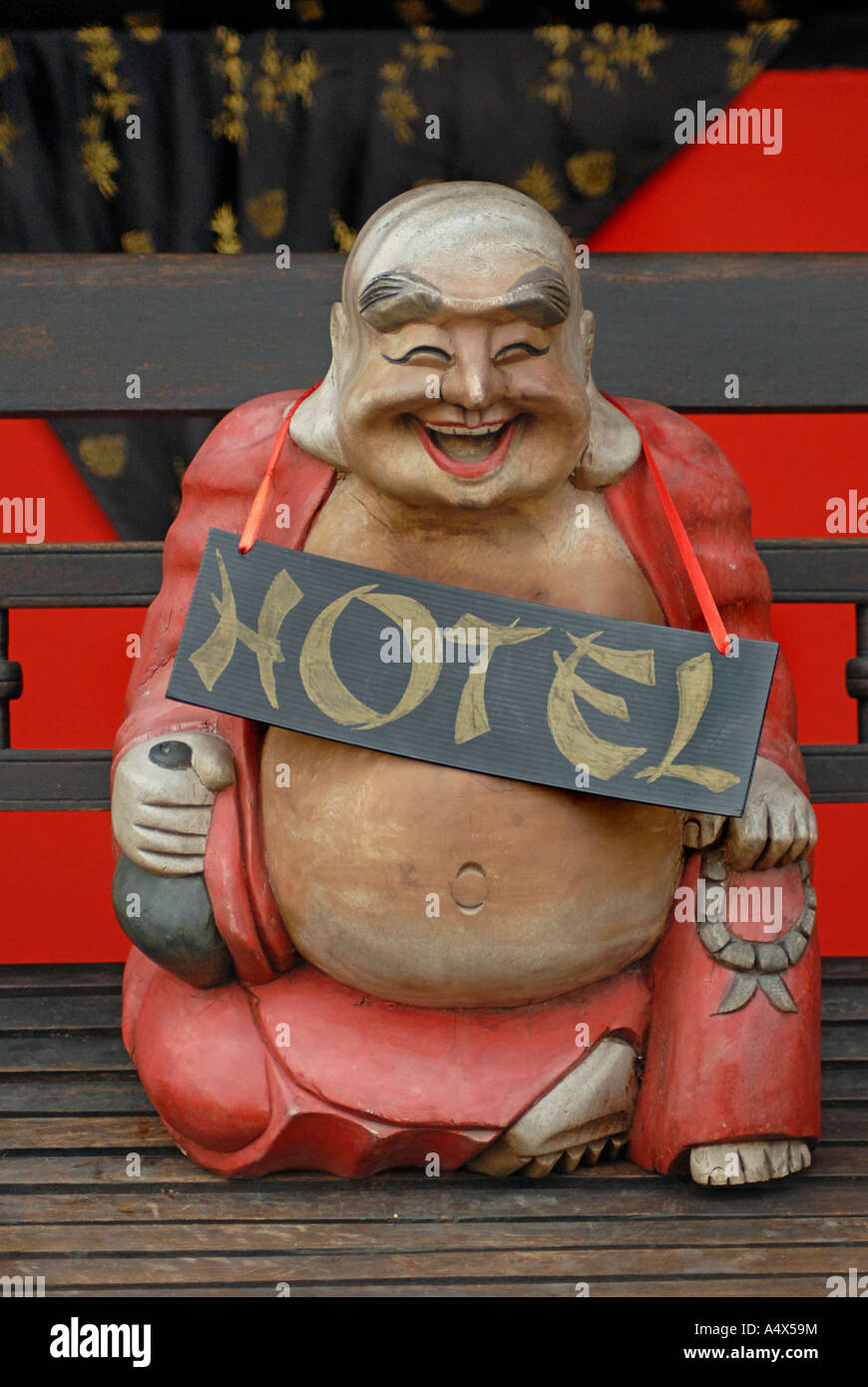 Glücklich lachende Buddhist wie Statue mit einem Schild Werbung HOTEL eines der sieben glücklichen Götter Koh Samui Thailand Stockfoto