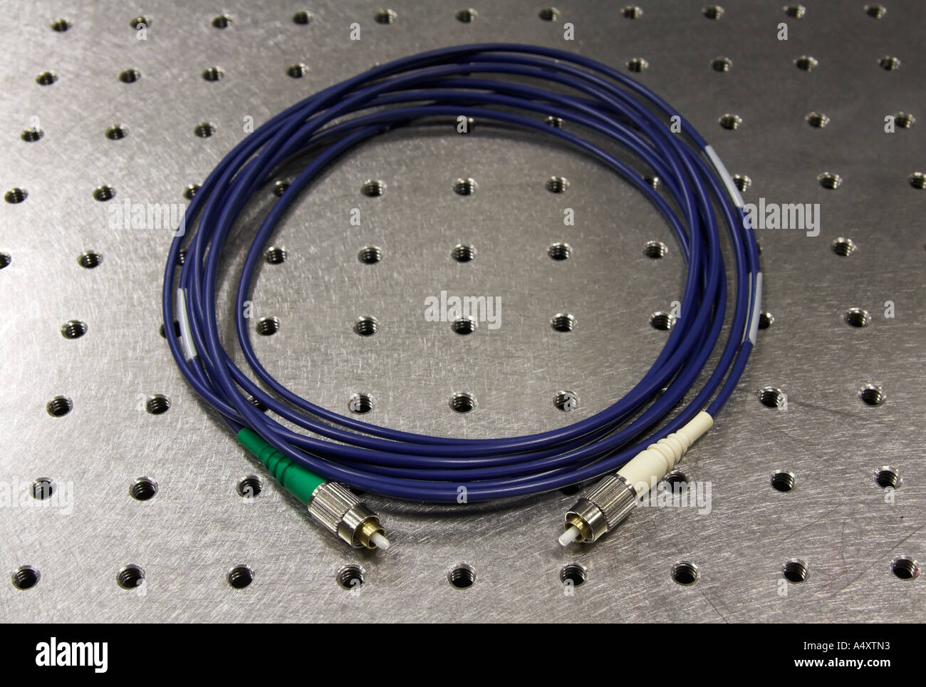 Ein Kevlar-ummantelten optisches Kabel aufgewickelt auf einer optischen Tisch, flachen Schärfentiefe Stockfoto