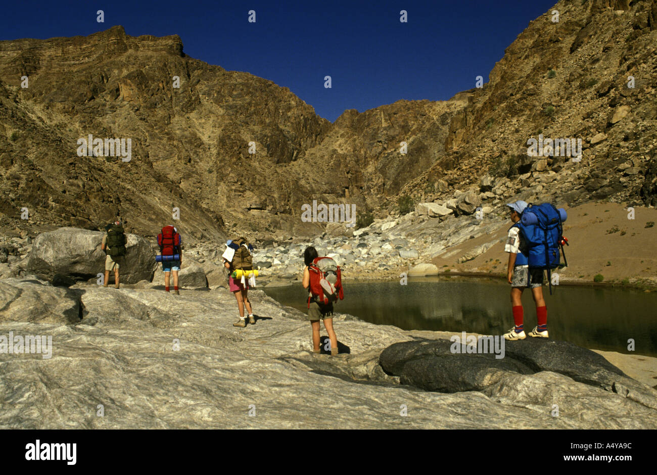 Eine Gruppe von fünf Wanderer zu Fuß entlang der felsigen Bettes des Fish River Canyon im Süden Namibias Südwestafrika Stockfoto