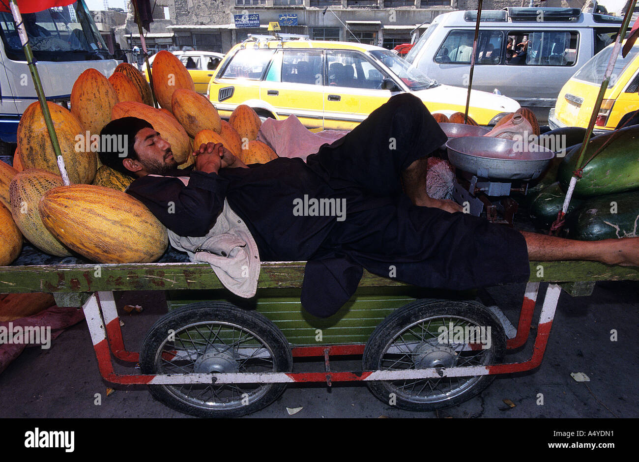 Auf der viel befahrenen Straße von Kabul zieht ein Melone-Anbieter einige Zeit für einen Schlaf Stockfoto