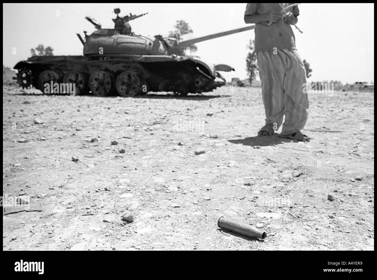 Kleiner Junge vor einem Panzer hinter eine Patronenhülse, Kirkuk Stockfoto
