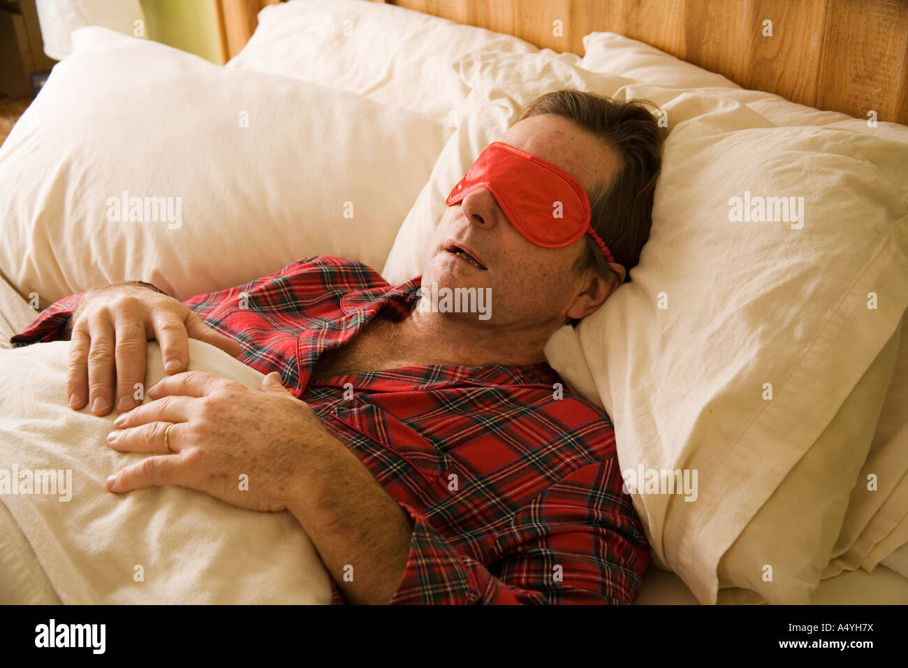 Mann schläft mit Augenmaske Stockfoto