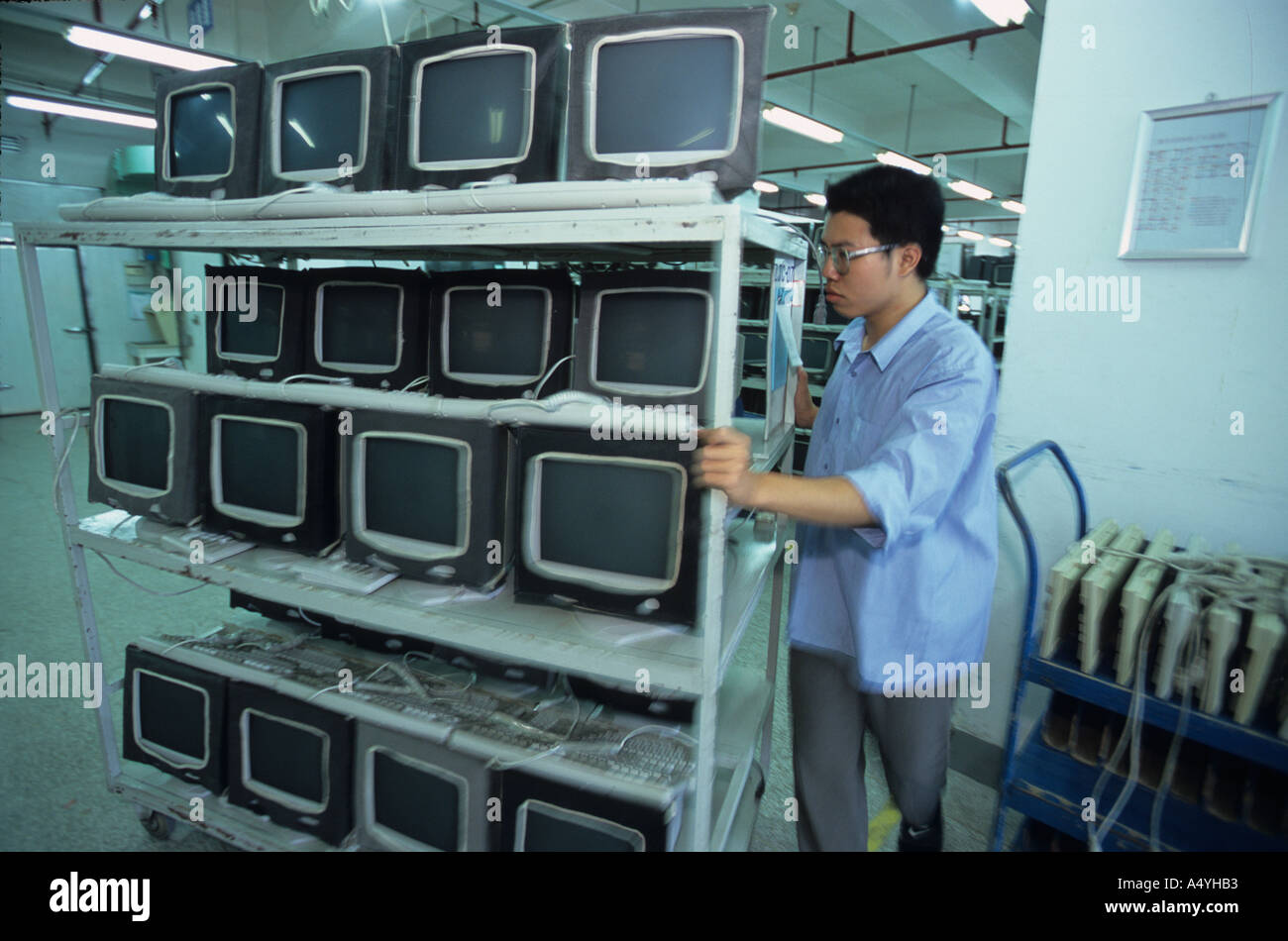 Ein Arbeiter zieht halbfertigen Produkte auf einem Wagen in einer Computer-Fabrik in Fujian China Stockfoto