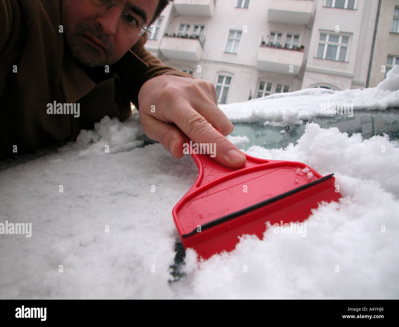 Ein Mannes ist sein Auto aus dem Schnee Reinigung Stockfoto