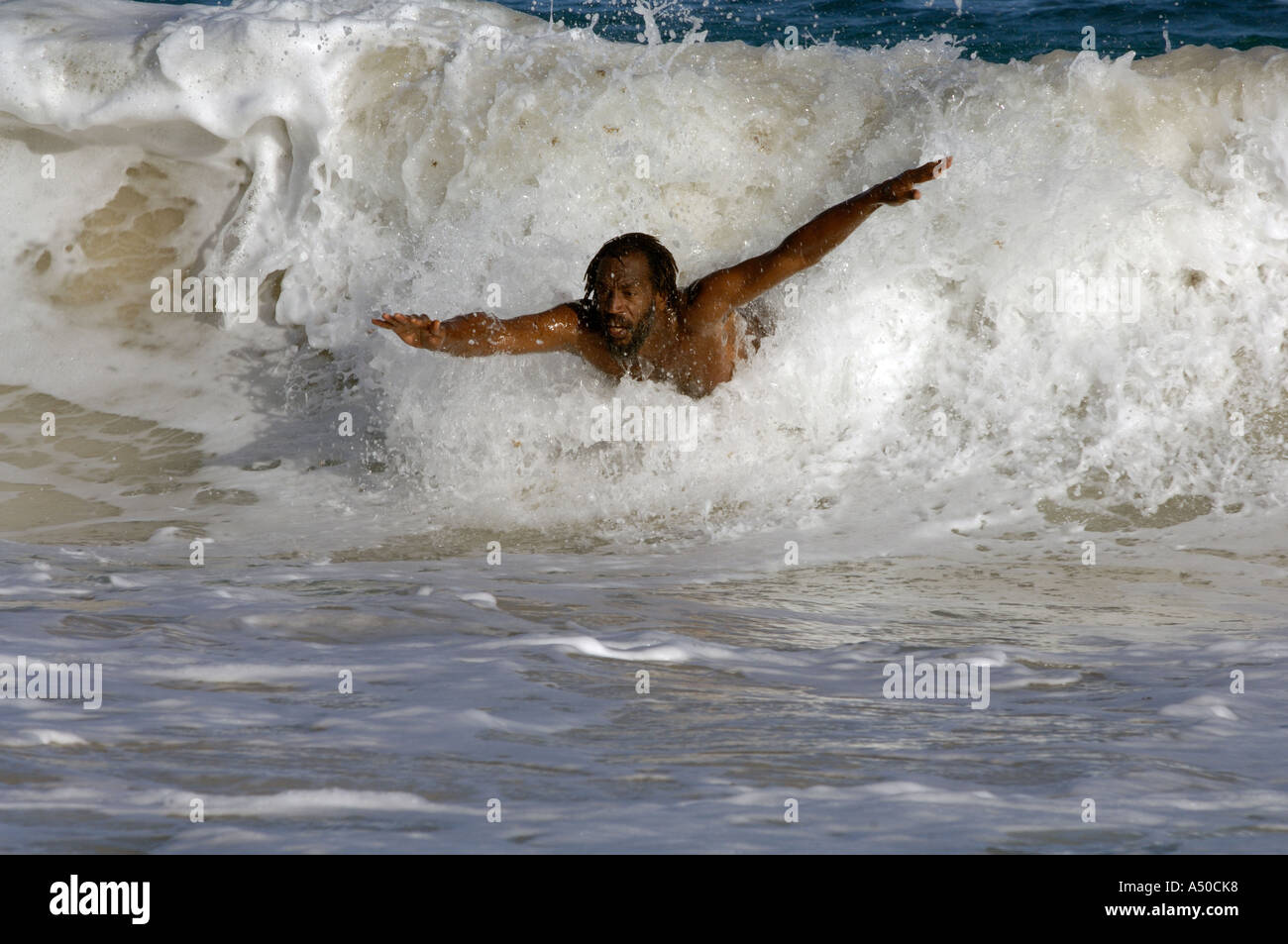 Schwarzen Bodysurfer reitet die Welle in Half Moon Bay, Antigua Stockfoto