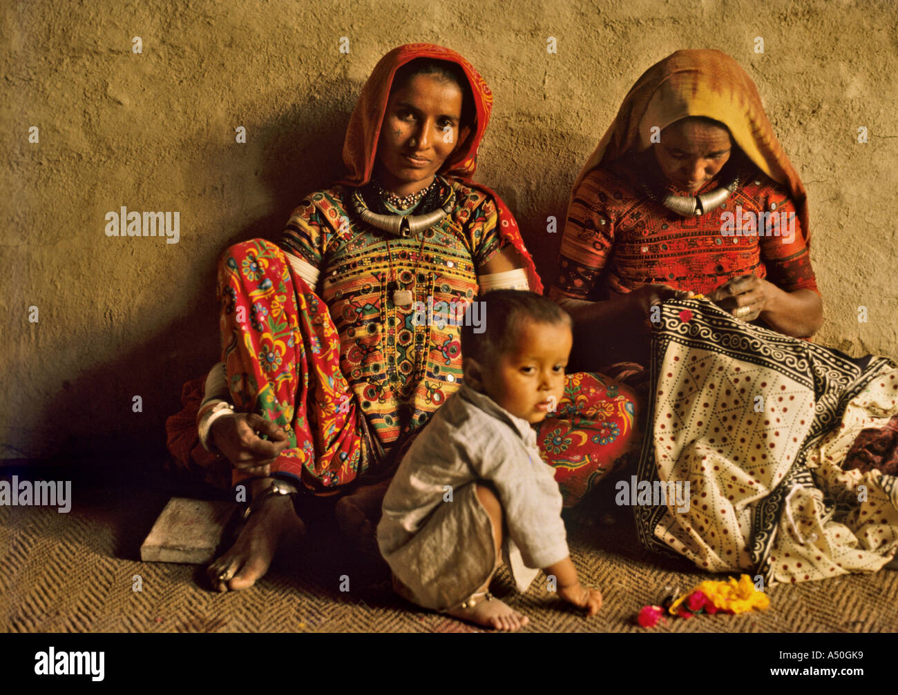 Frauen sitzen mit einem Kind in Gujarat Stockfoto
