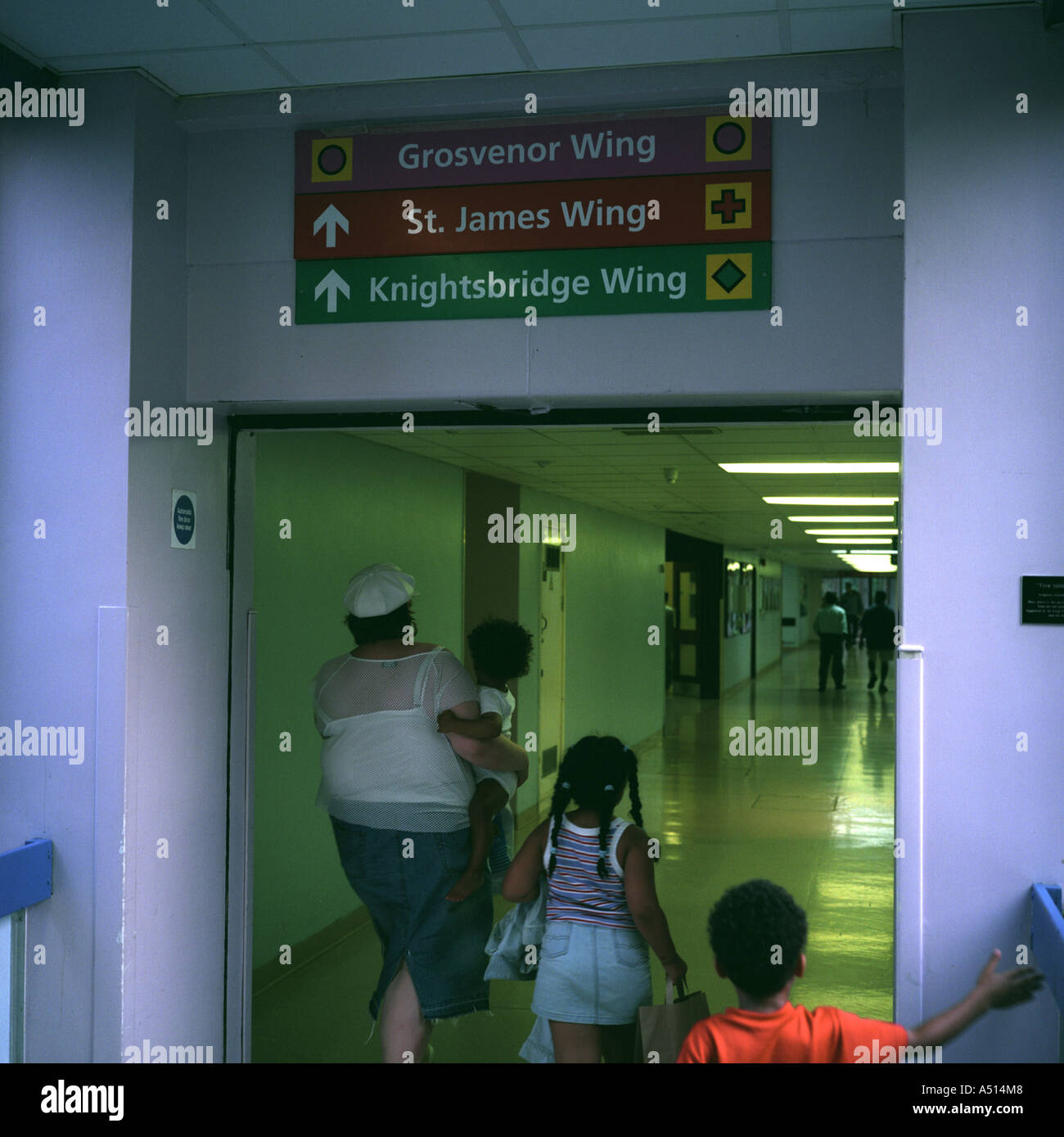 Eine Familie, die hinunter einen Krankenhausflur am St Georges Hospital, Tooting, London, UK. Stockfoto