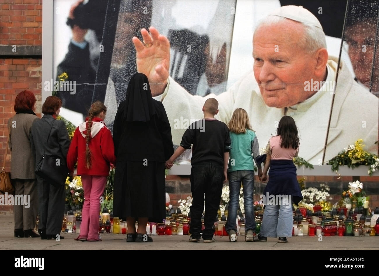 Eine Gruppe von Menschen Hände kam, begleitet durch einen christlichen religiösen Blick auf die brennenden Kerzen in Gedenken an Johannes Paul II. Stockfoto