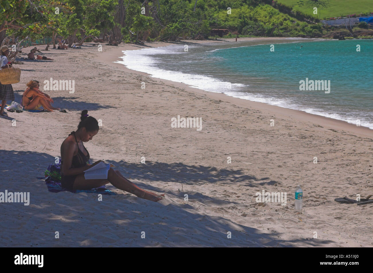 Frau sitzt am Morne Rouge Strand Grenada lesen Stockfoto