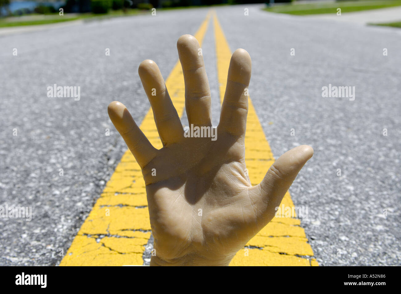 konzeptuelle Ansicht der männlichen Hand auf gelben Streifen in Fahrbahn Stockfoto