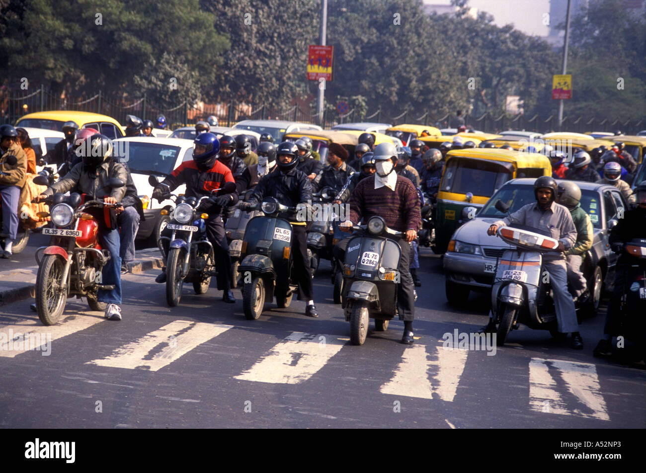 Motorroller Motorräder und drei Rädern Auto Taxis jockey für Position an einer Ampel auf eine Kreuzung Straßen in Delhi Indien Stockfoto