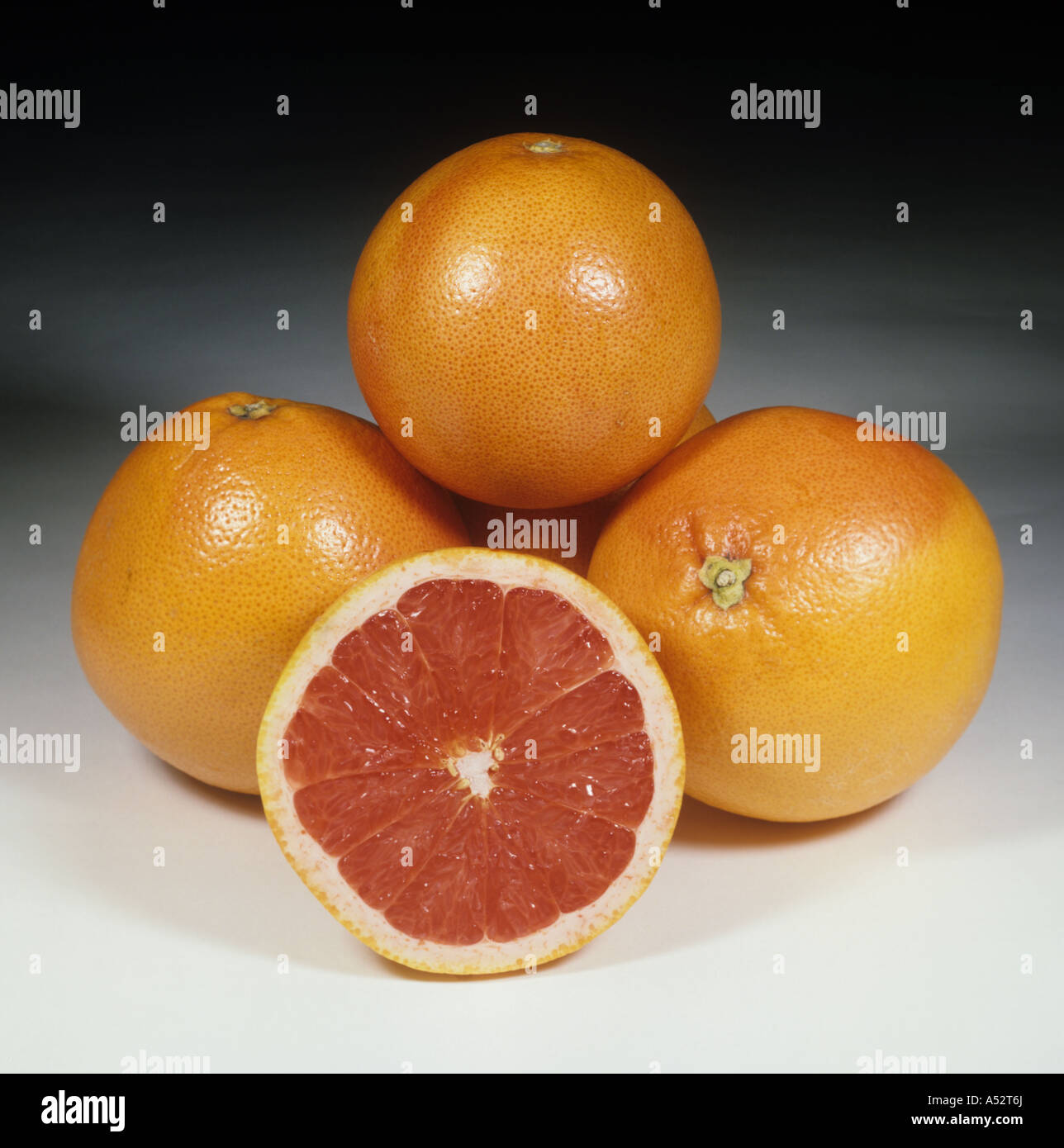 Ganze und geschnittenen rosa Grapefruit Obstsorte Marsh Ruby Stockfoto