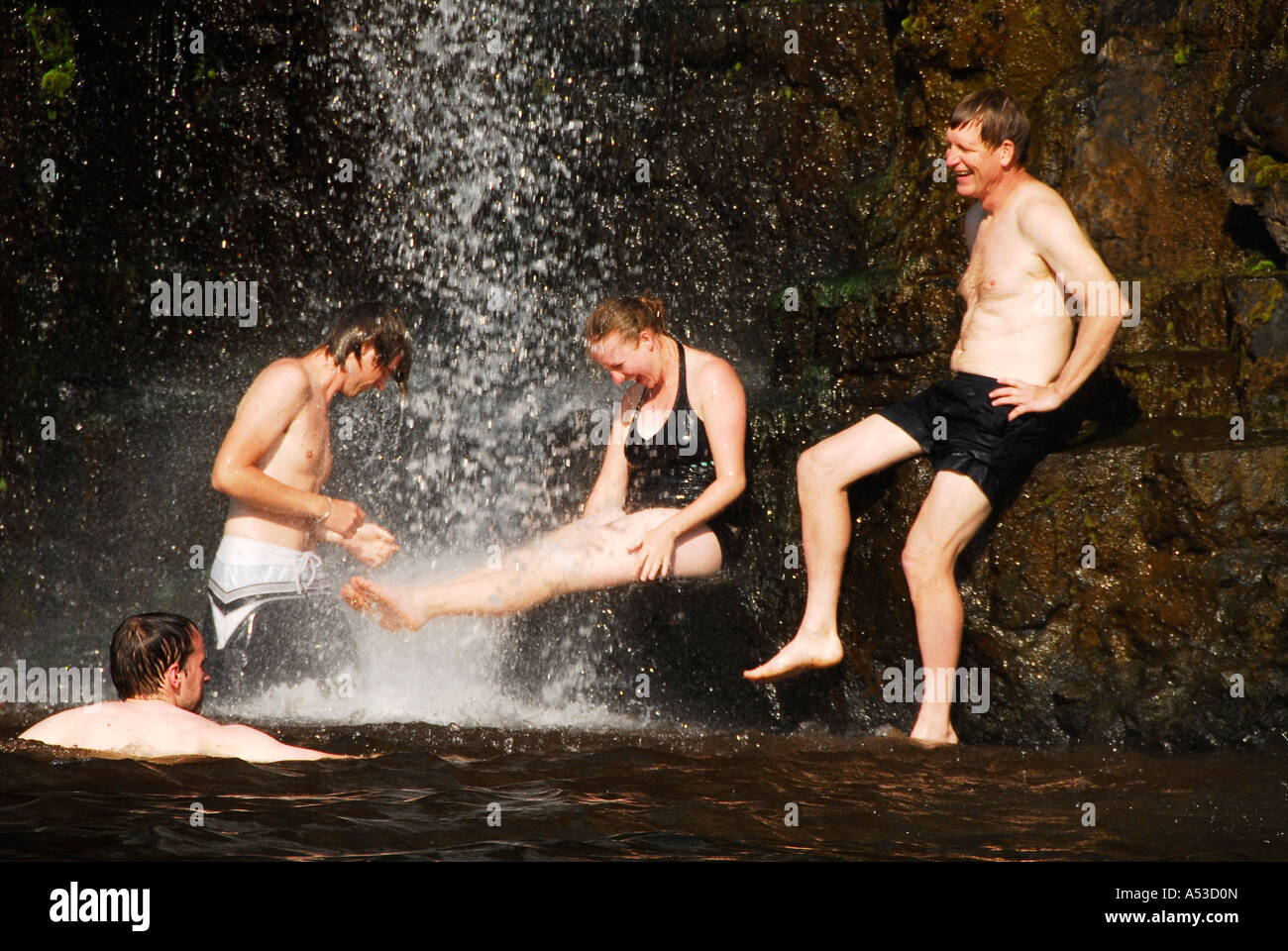 Freunde unter das kühle Wasser des Wasserfalls Wald in der Nähe von Graskop und Sabie, Mpumalanga, Südafrika Stockfoto