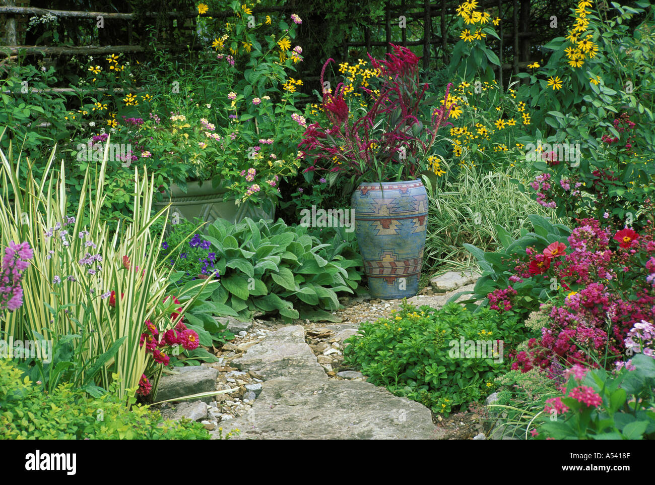 Steinplatten Weg in bunt blühenden Blumengarten mit bunt bemalte Topf, Missouri USA Stockfoto