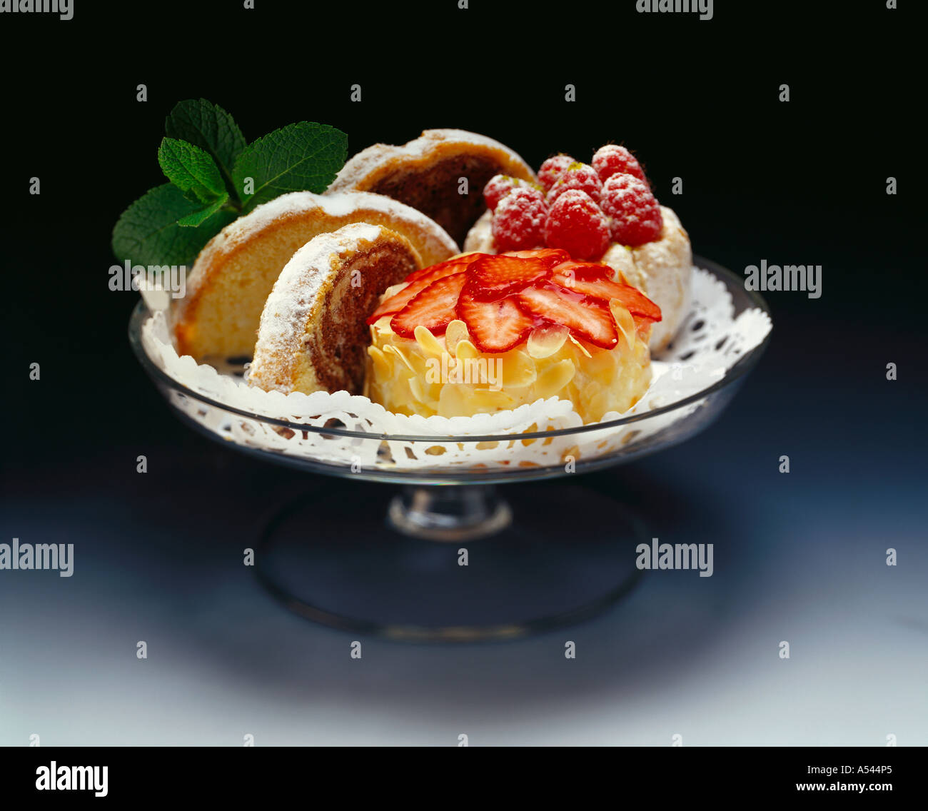 Zwei kleine Kuchen mit Beeren und ein paar Stücke von Marmorkuchen Stockfoto