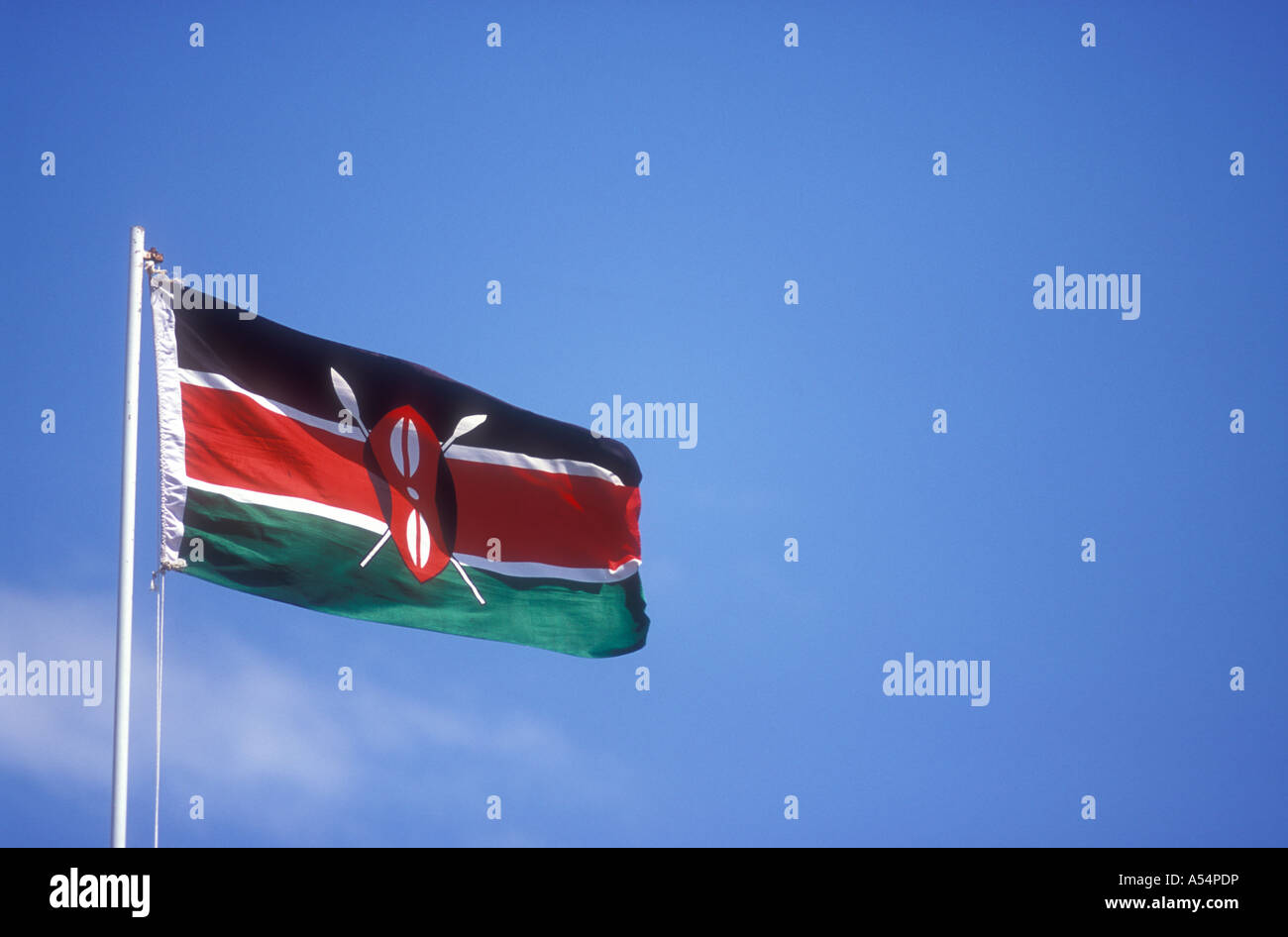Die Nationalflagge von Kenia in Ostafrika auf einem weißen Fahnenmast vor einem blauen Himmel fliegen Stockfoto