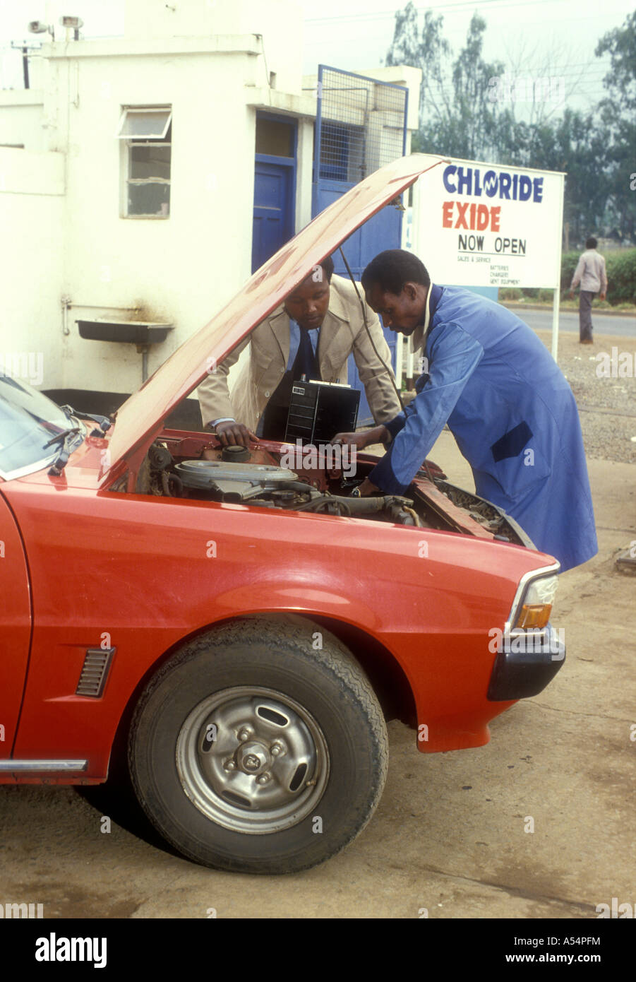 Garage Mechaniker Montage einen neuen Akku zu einem privaten Auto Nairobi Kenia in Ostafrika Stockfoto
