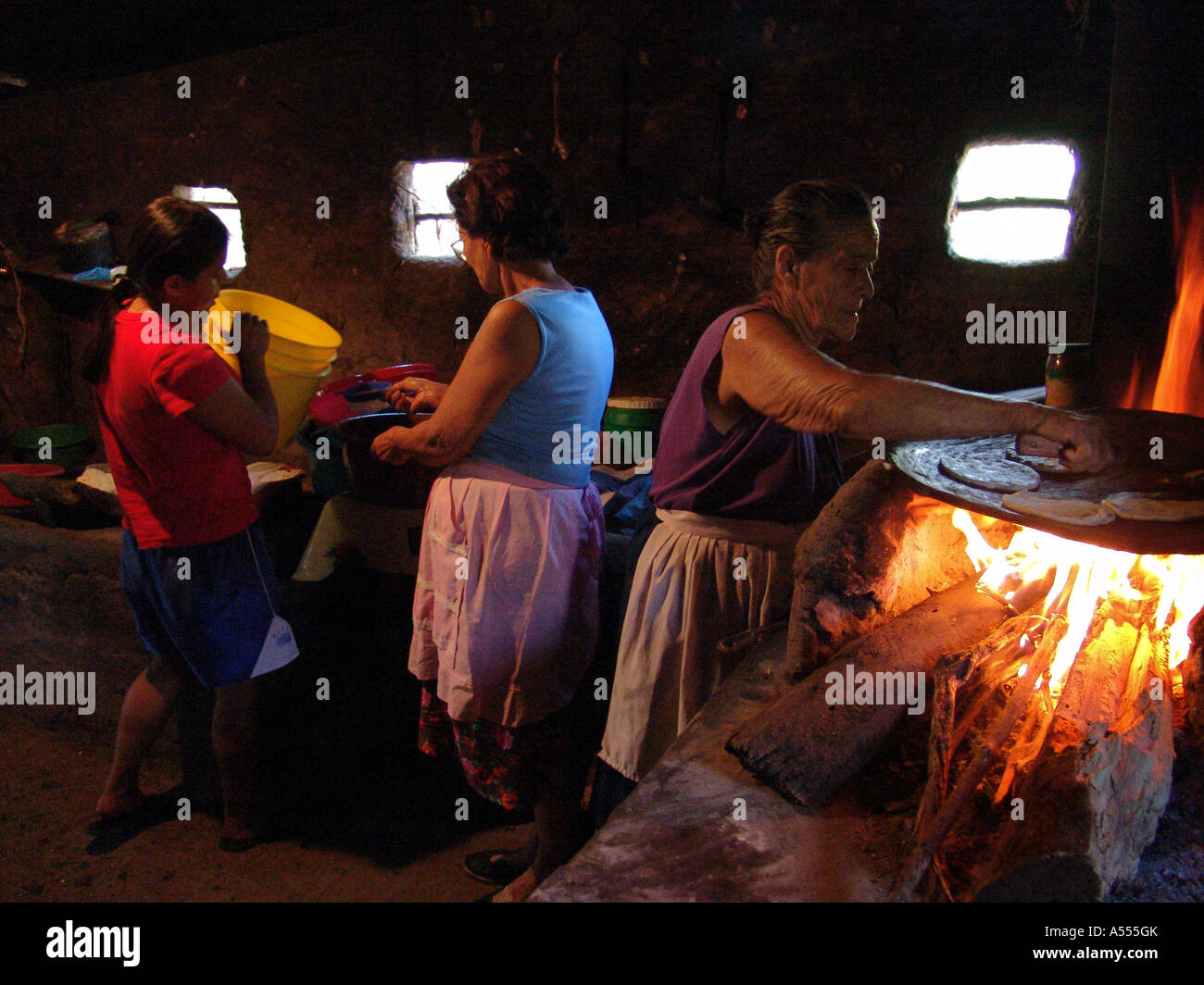Painet ip2535 Salvador ältere Frau Tortillas öffnen Feuer Tochter Enkelin Gießen Milch Eimer Paisnal Land entwickelt Stockfoto