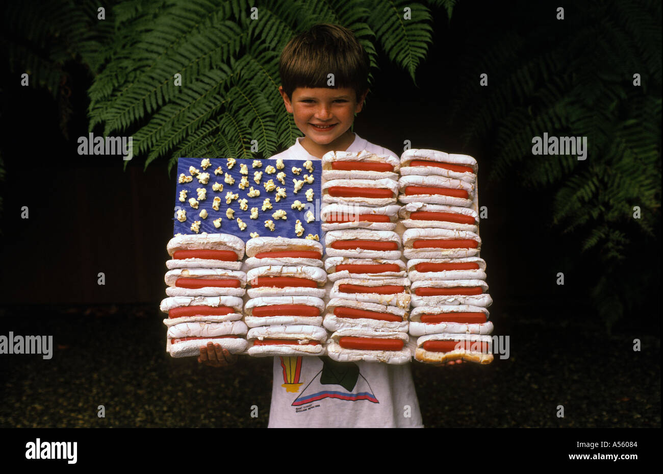zehn Jahre alter Junge amerikanische Flagge aus Hotdogs Brötchen und Popcorn gemacht Stockfoto