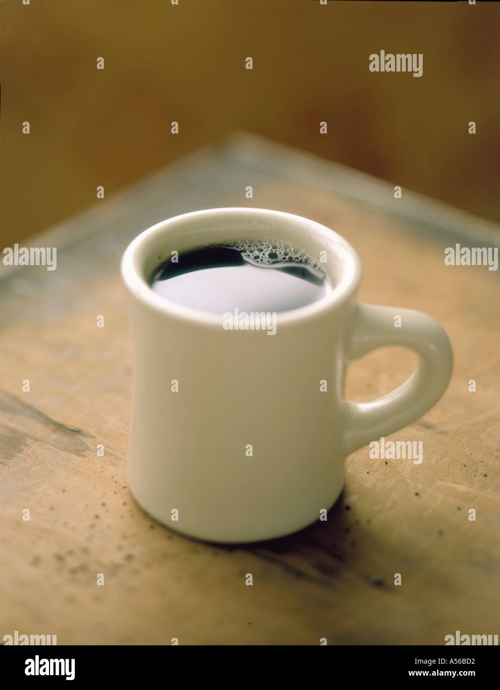 Tasse Kaffee auf der Ecke des Tisches sitzen Stockfoto